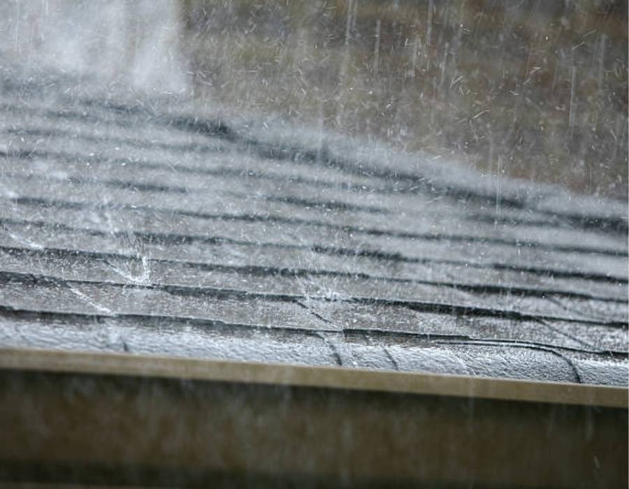 Heavy rain falling on asphalt shingle roof of a Maryland home