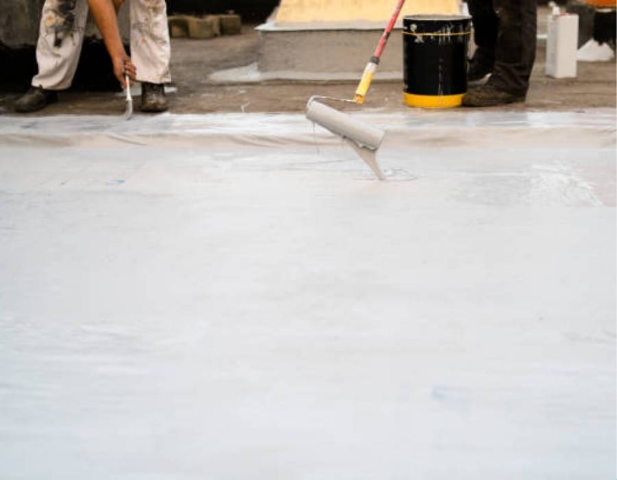 Workers applying silicone roof coating on a Maryland commercial flat roof for added protection